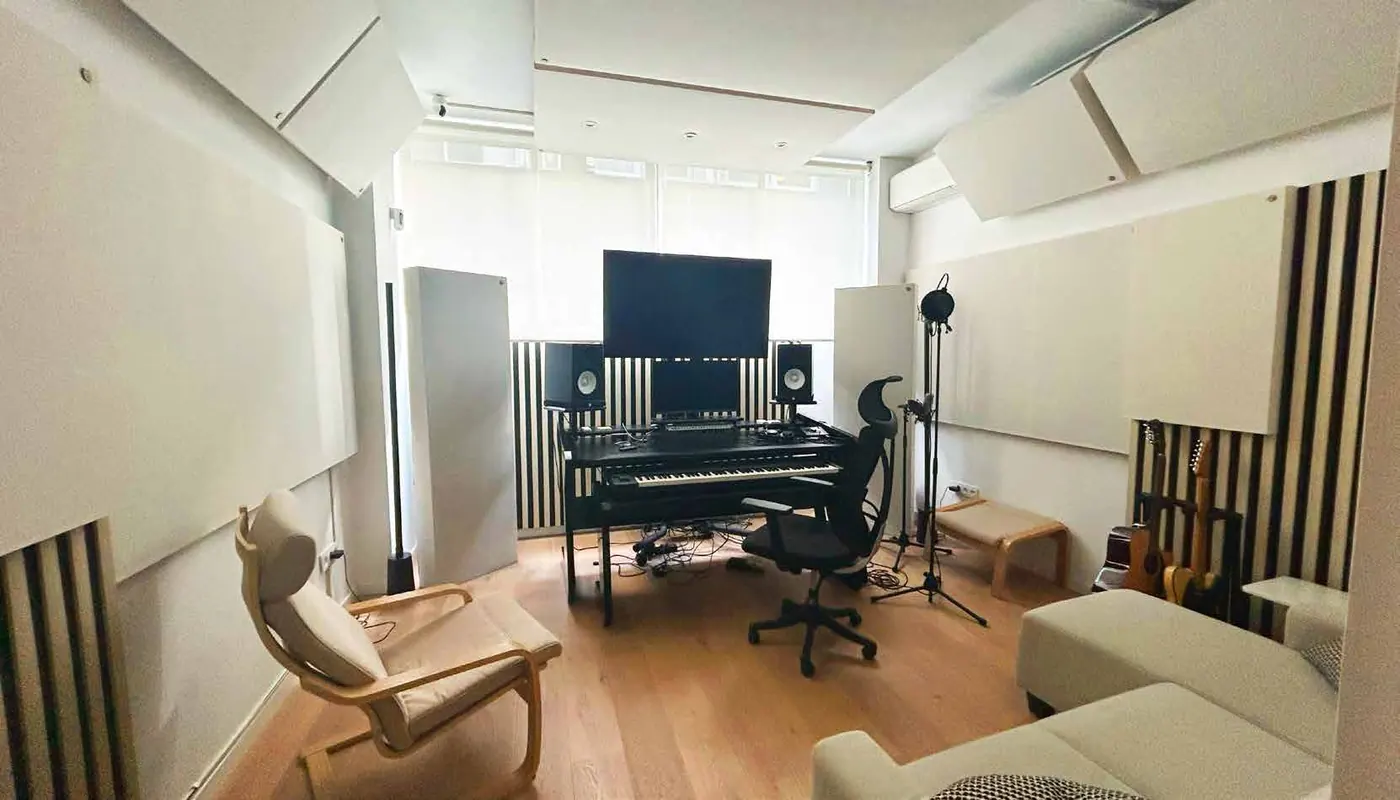 Side view of the studio with armchair, production desk and acoustic panels