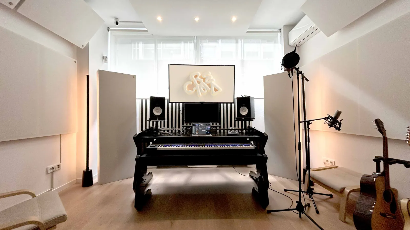 CREMA Studio main room with production desk, keyboard, Yamaha monitors and guitars
